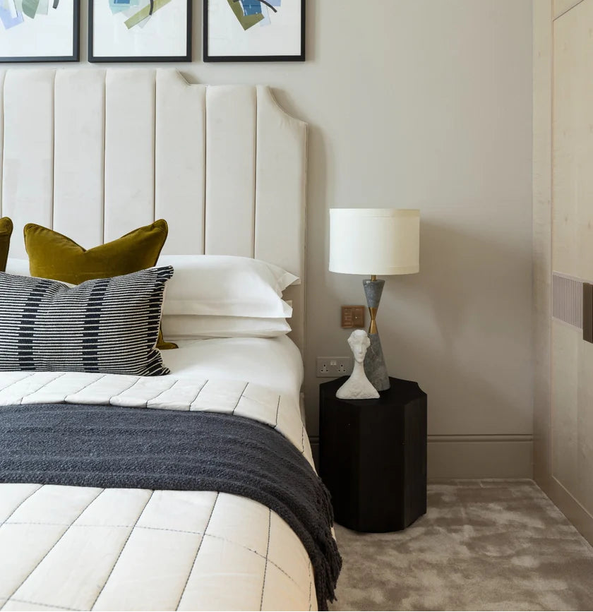 Modern bedroom with a bed, nightstand, and wall art.