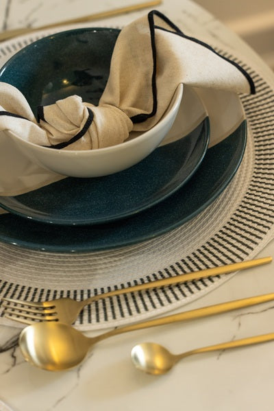 table setting with blue and white bowls with gold cutlery