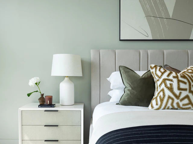 Modern bedroom with a bed, nightstand, and wall art.