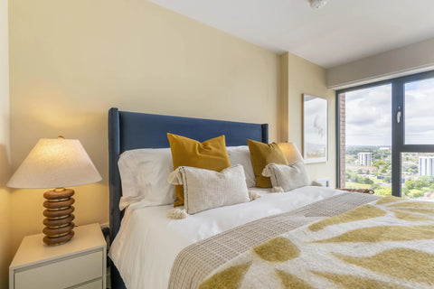 apartment bedroom with furnished bed with mattress, bedside table and accessories