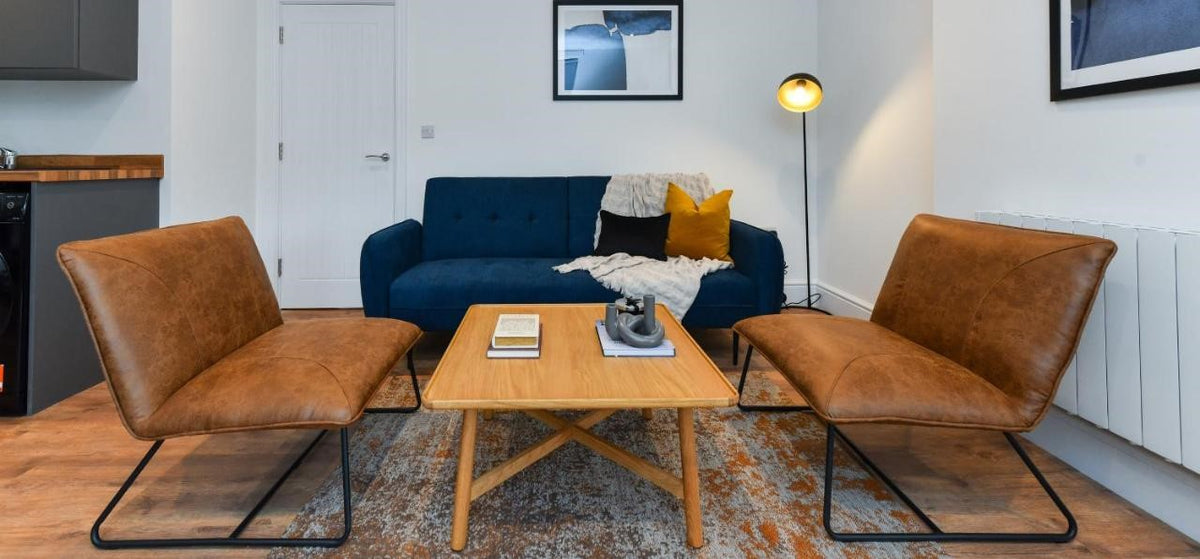living area with dark blue sofa, coffee table and occasional chairs