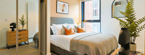 Modern bedroom with a bed, dresser, and decorative elements.