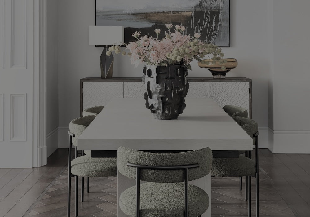 Dining room with a table and chairs, featuring a vase with flowers on the table.