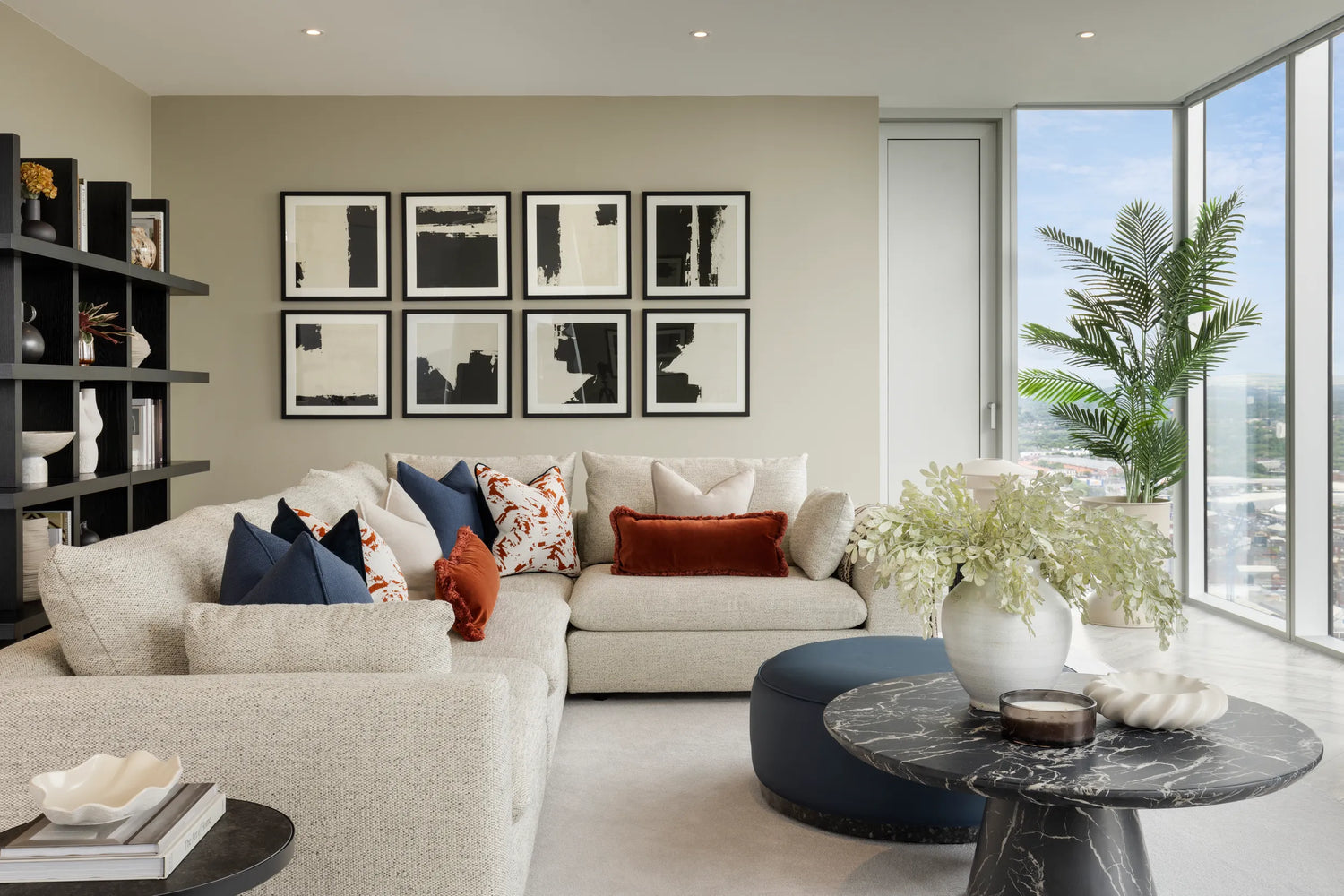 modern apartment living room with white corner sofa, black marble coffee table and accessories