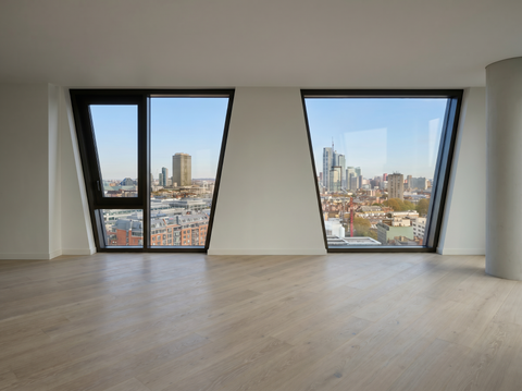 Modern room with large windows offering a cityscape view.