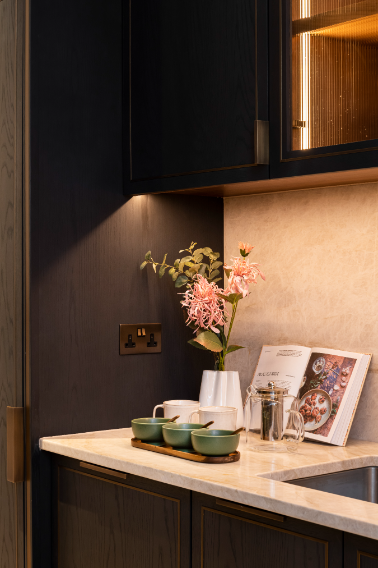dark kitchen area with downlights, and green bowls with cookbook