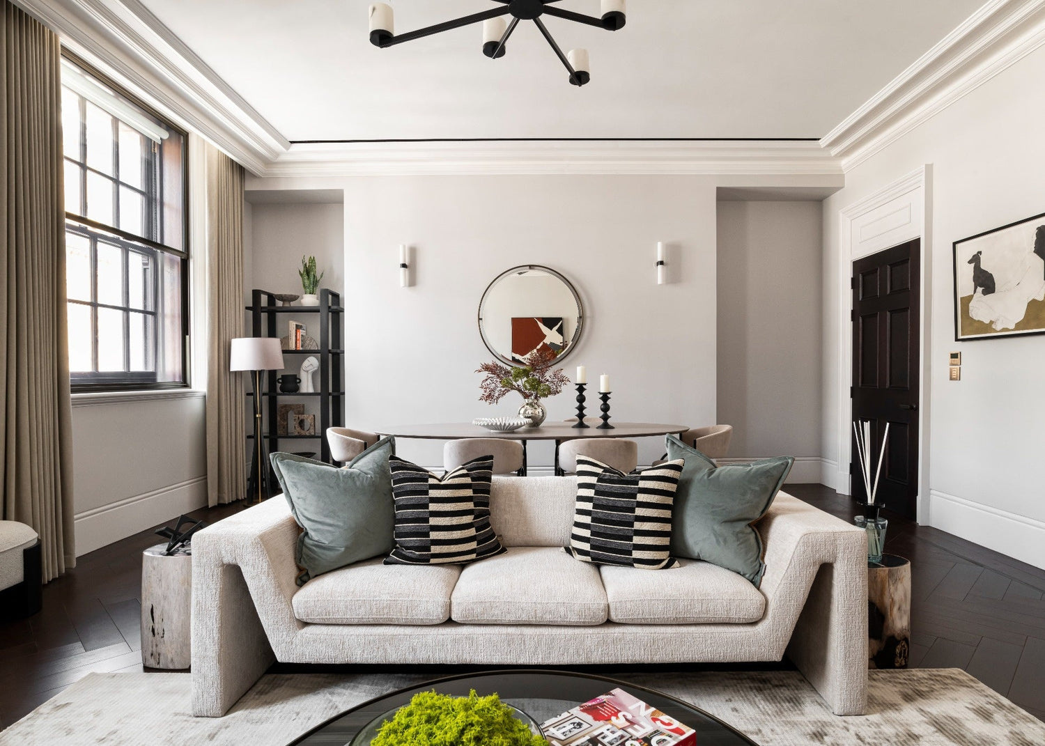 Modern living room with a beige sofa, decorative pillows, and a round coffee table.