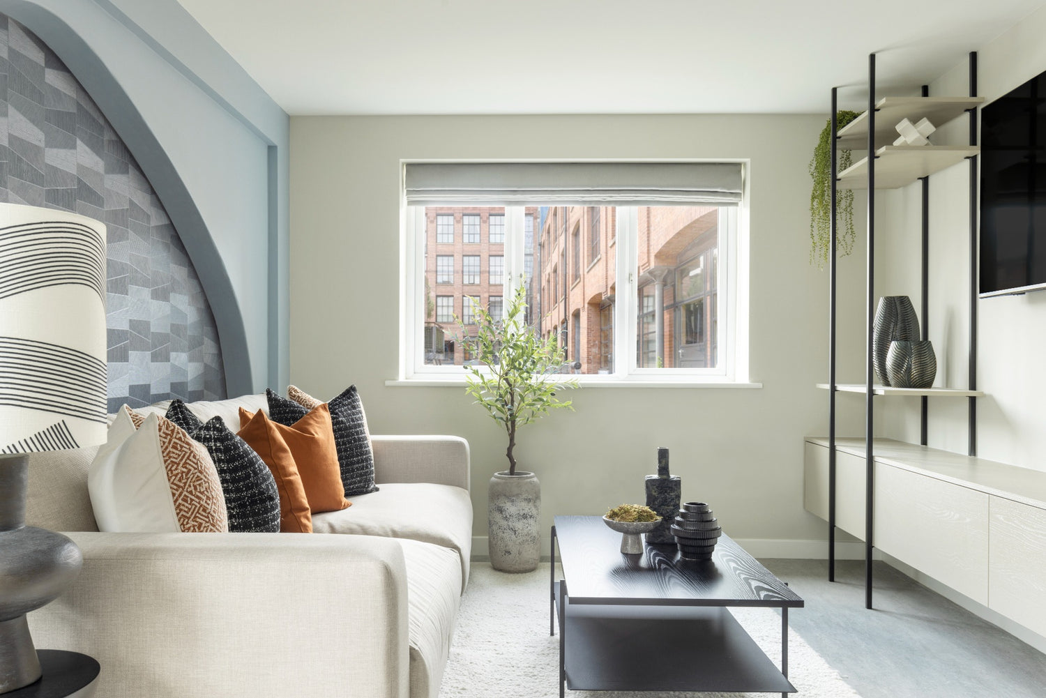 Modern living room with a sofa, coffee table, and decorative items.