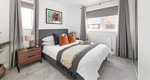 Neatly arranged bedroom with a bed, bedside table, and decor elements.